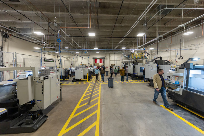 photo of an overall view of one room in the Advanced Manufacturing & Material Center on campus with the machines and people