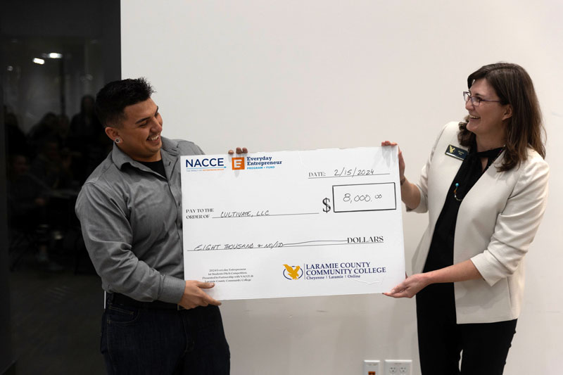 Man and women presenting large mock check