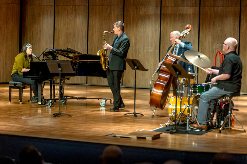 Photo of LCCC Music Faculty playing on stage with a piano, saxophone, base and drums