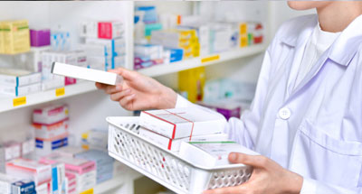Photo of a pharmacy tech getting medicines of shelves