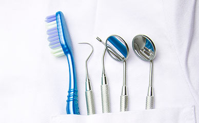 Dentistry utensils in the pocket of a lab coat