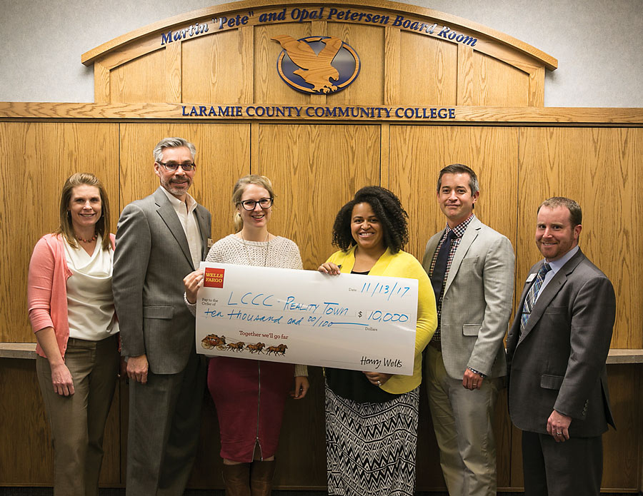 Matt Burgess (left) presents a $10,000 gift to LCCC in support of Reality Town, an event to help high school students understand the importance of education and planning as part of adult life skills. Jasmine Varos (center) and Adam Keizer (fourth) of the GEAR UP program reach thousands of students each year.