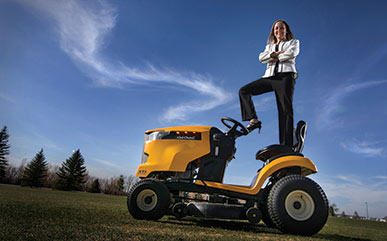 Bailey Nowak standing on lawn mower