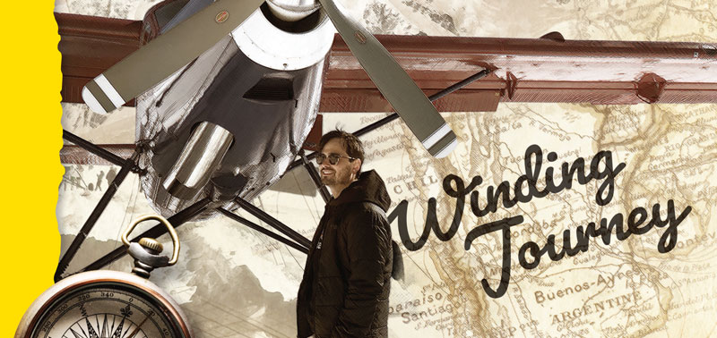 Santiago Lovisolo standing in front of a map, next to a compass and below an airplane with the words Winding Journey