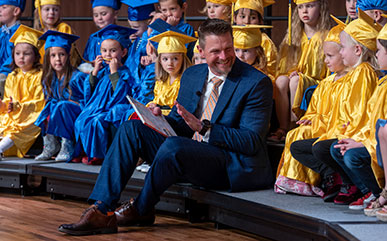 photo of President Schaffer reading to the Children's Discover Center graduates.