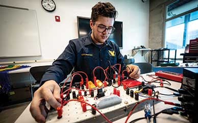 diesel tech student working with electronics with board and wires