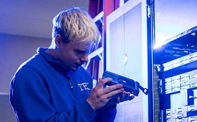 Jordan Ream working on a computer server part on campus