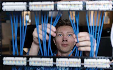a student looking through computer wires/cables