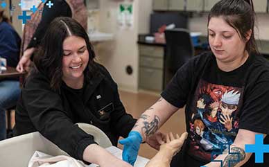 faculty member and student in a Health Sciences lab classroom with gloves on