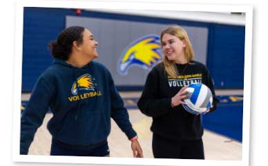 Lea and Zoe holding a volleyball and talking