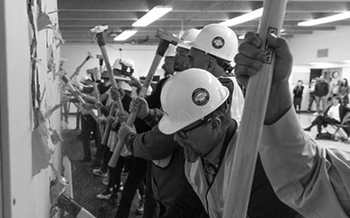 photo of groundbreaking for the RAC with people hitting a wall with sledge hammers