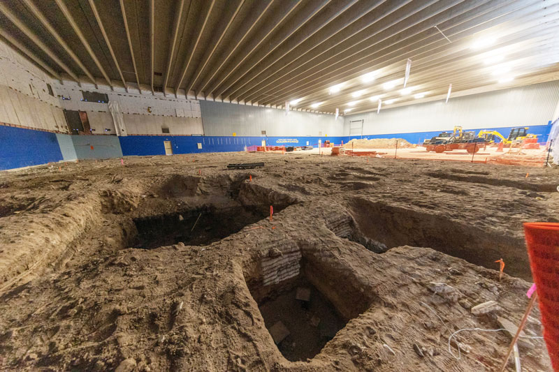 Photo of the RAC construction when working in the competition gym and digging holes in the dirt floor to add foundation