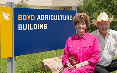 Bob and Regina Boyd in front of the Boyd Ag Building sign on campus