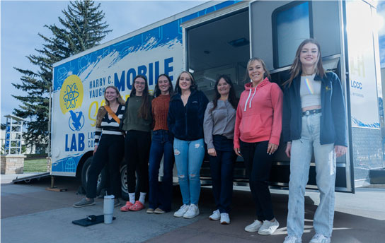 photo of students standing in a line in front of the mobile science lab