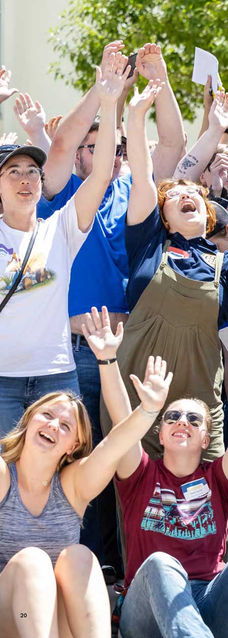 A crowd of students with their arms up