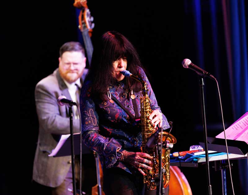Joy Harjo on stage singing with a band on stage