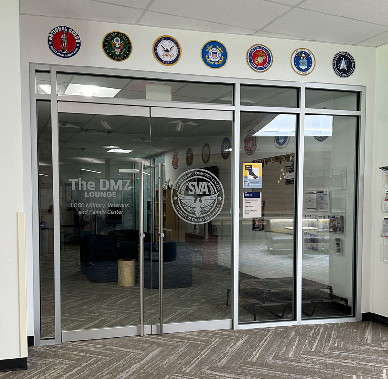 The sign on the glass entrance to the DMZ Lounge that says "The DMZ Lounge, LCCC Military, Veterans, and Family Center"