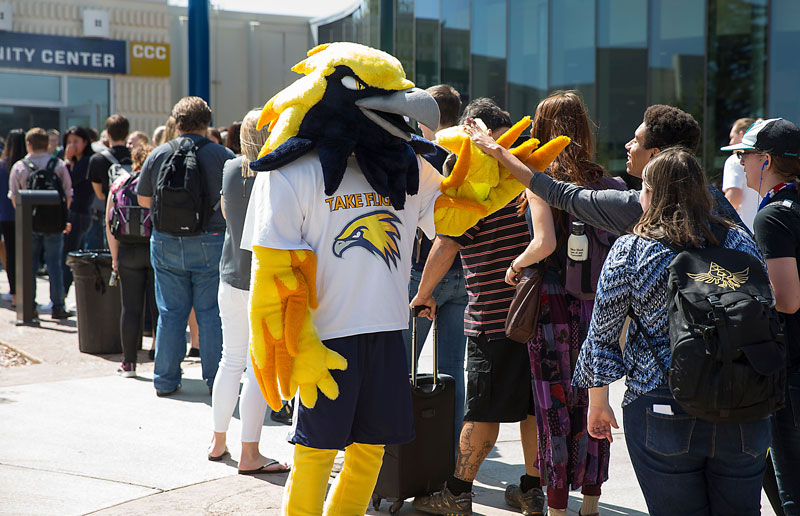 Talon the mascot high fiving a group of students