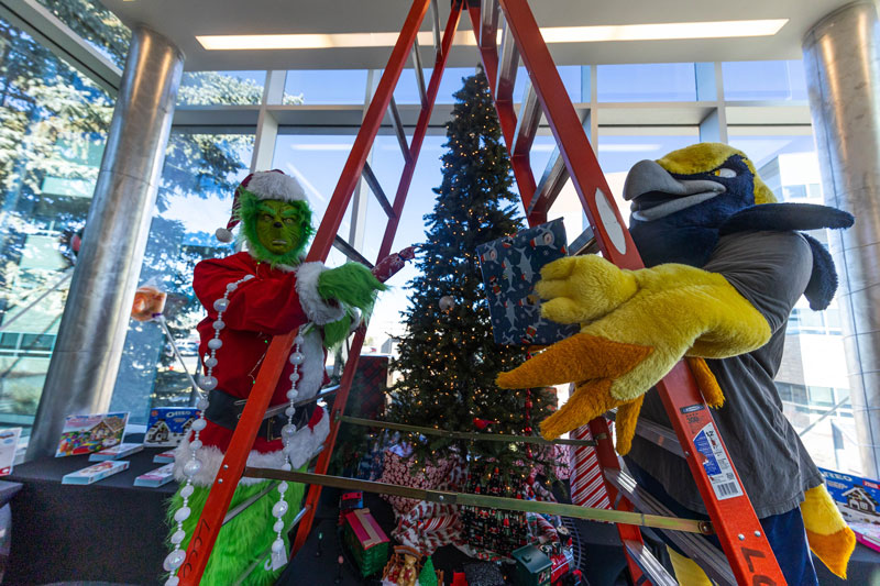Talon the mascot in the Dining Hall on campus with The Grinch decorating for the holidays