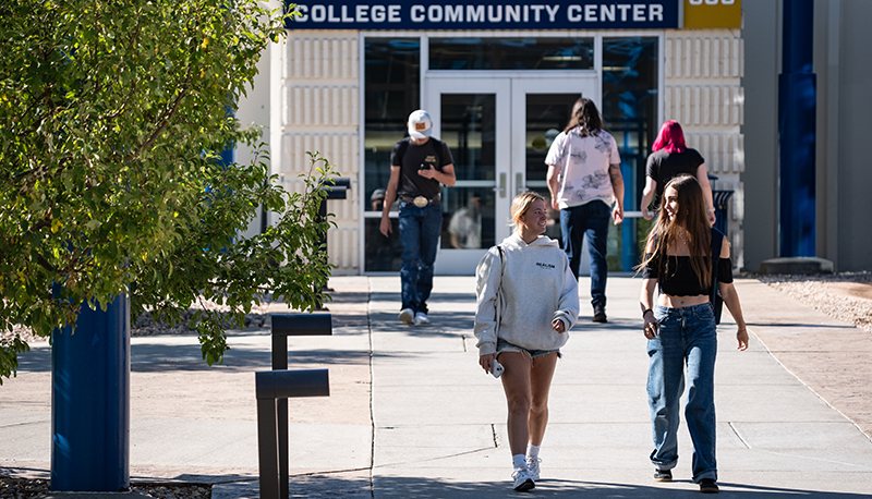 several student walking from the College Community Center to the Clay Pathfinder Building.