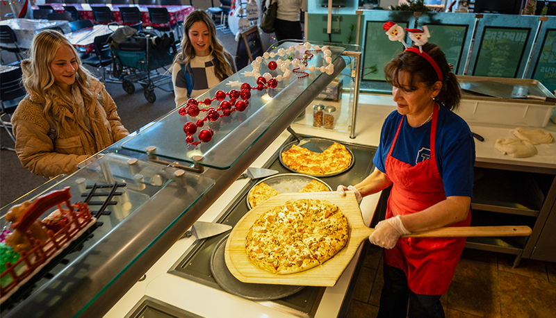 two students getting pizza from the dining hall