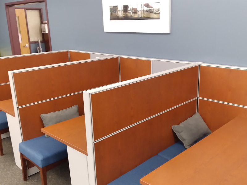 3 study carrels with tables, a bench and pillow in each