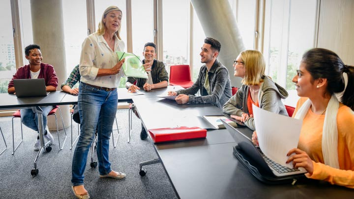 Woman teaching others around a table