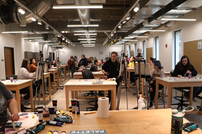 Photo of students in the art classroom during a sip and paint event for all students on campus