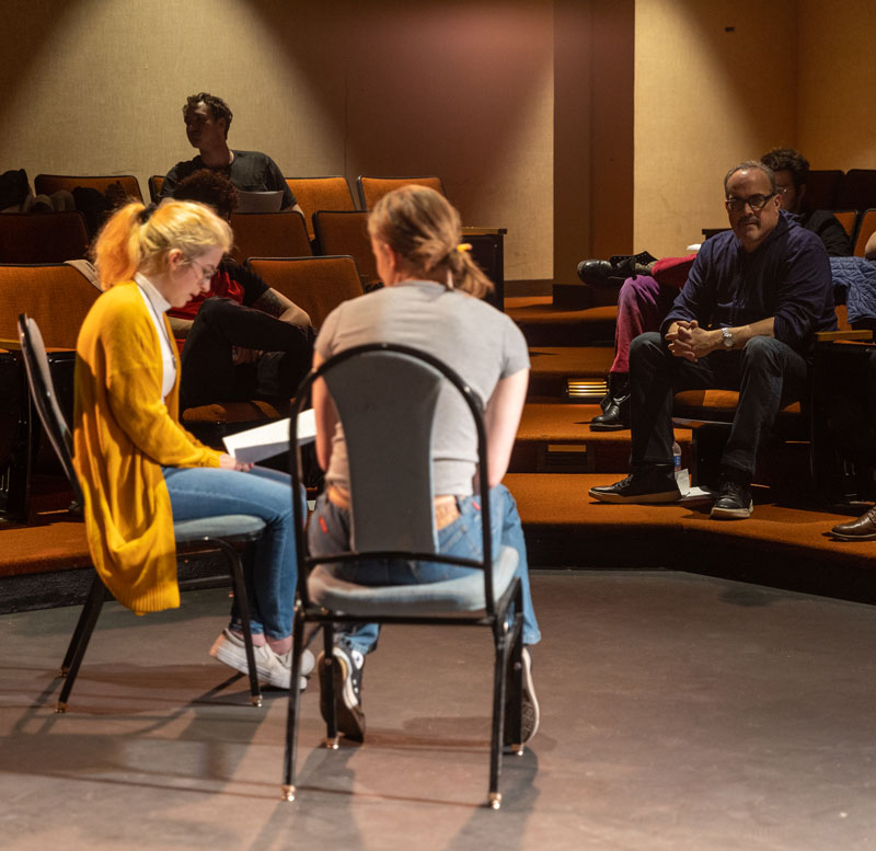 LCCC students sitting on stage in the Playhouse with people in the audience