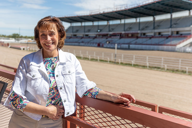 photo of Renee Middleton standing in the arena stands at Cheyenne Frontier Days with and empty arena behind her