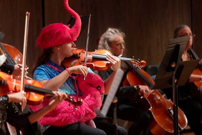 Halloween concert with the musicians wearing costumes and playing violins