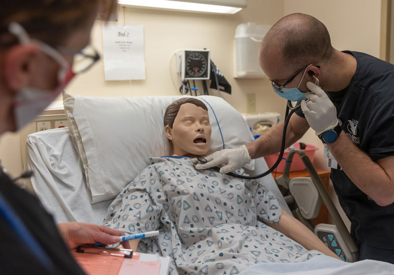 Photo of two nursing students with a simulator patient in the LCCC Sim lab.