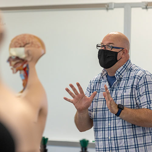 faculty member teaching anatomy with a model body 