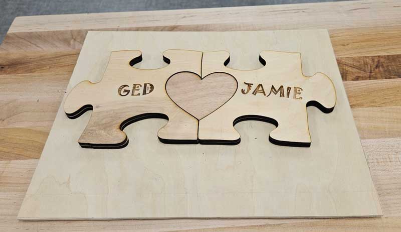 Laser cut puzzle with a heart in the middle and two people's names