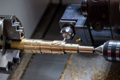 photo of a metal lathe cutting a brass part